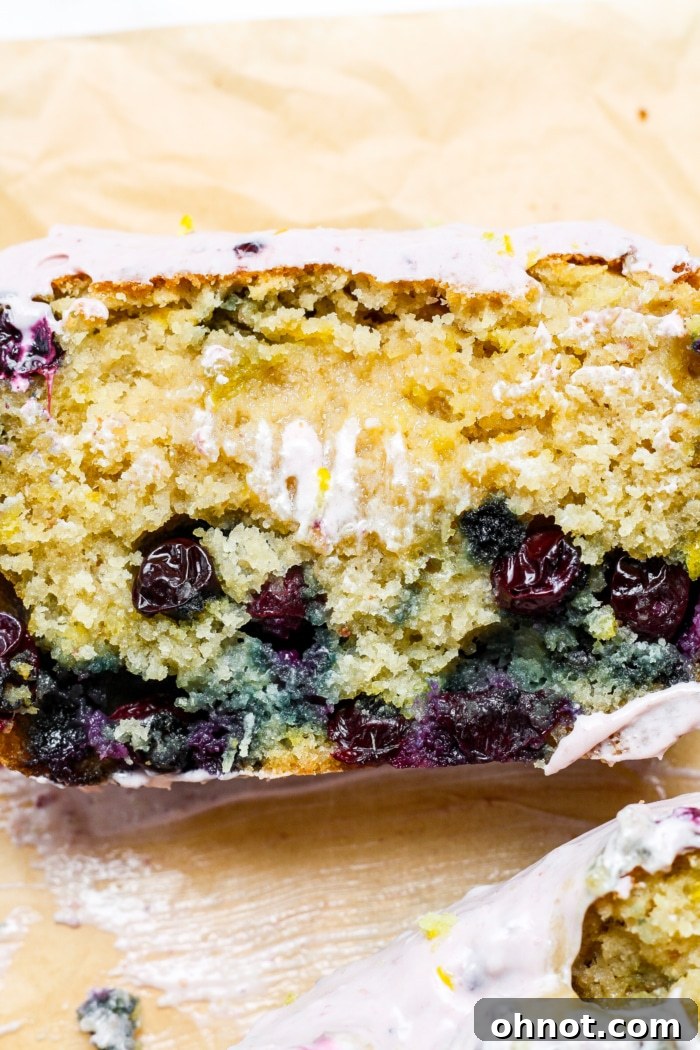 Close-up of a slice of lemon blueberry bread with frosting.