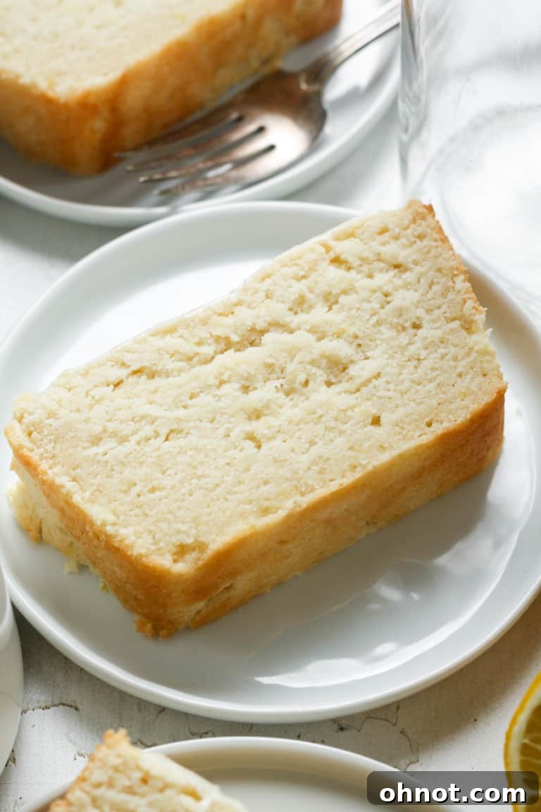 A slice of elegant vegan pound cake with a light glaze on a plate.