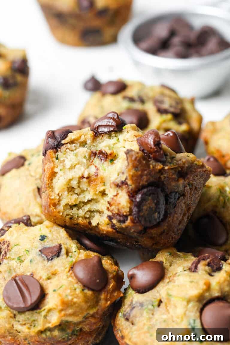 Golden vegan zucchini muffins with visible flecks of zucchini.
