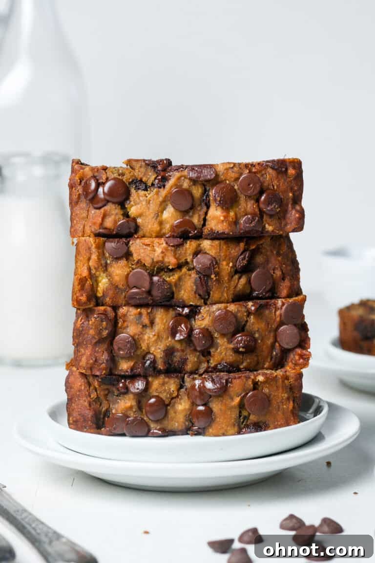 A slice of vegan chocolate chip banana bread with melted chocolate chips.