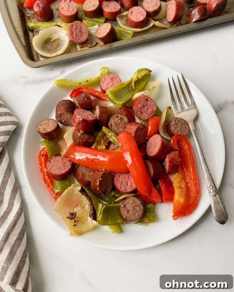 A vibrant plate of grilled sausages, roasted red and green bell peppers, and caramelized onions, perfectly cooked and ready to eat.