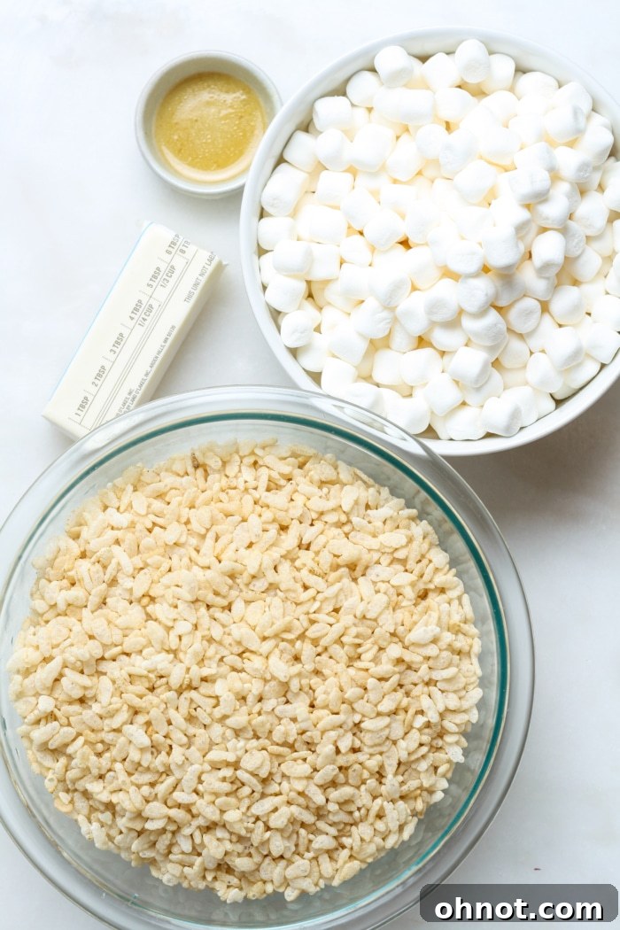 Key ingredients for homemade gluten-free rice krispies treats including butter, marshmallows, vanilla, and gluten-free cereal