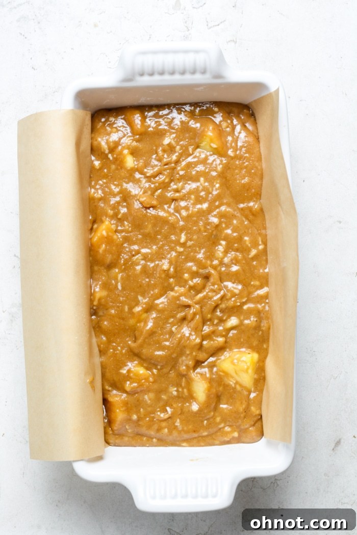 Pineapple banana bread batter in a loaf pan, ready for baking.