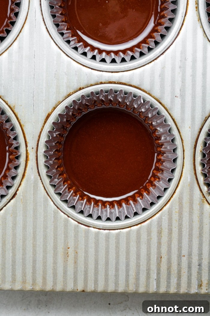Muffin liners with a base layer of melted chocolate.