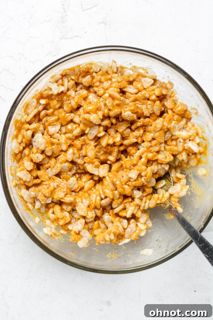 Rice cereal mixed with peanut butter and maple syrup in a bowl.