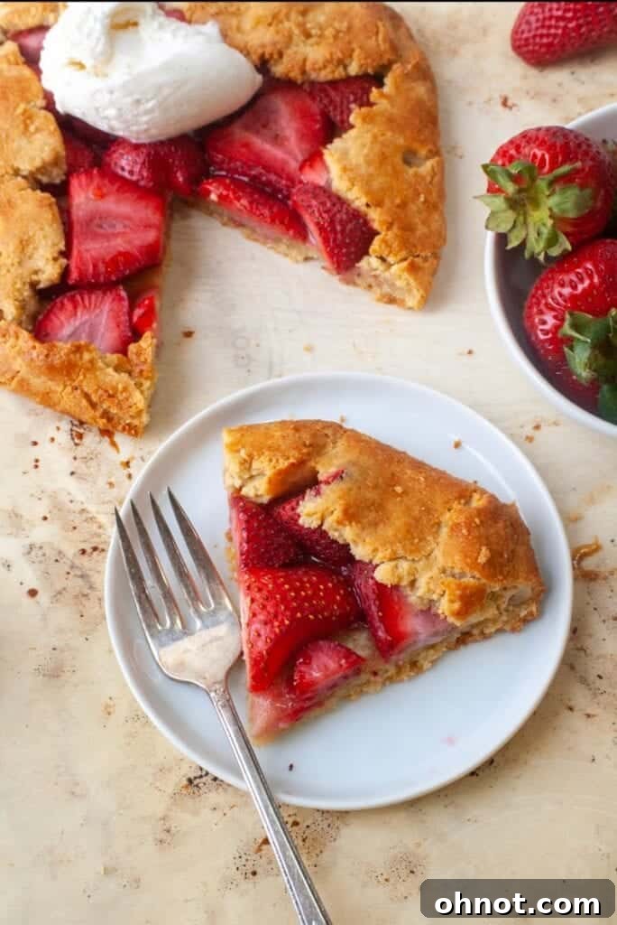 A single slice of gluten-free strawberry galette on a white plate, showcasing the vibrant strawberry filling and golden crust, ready to be enjoyed.