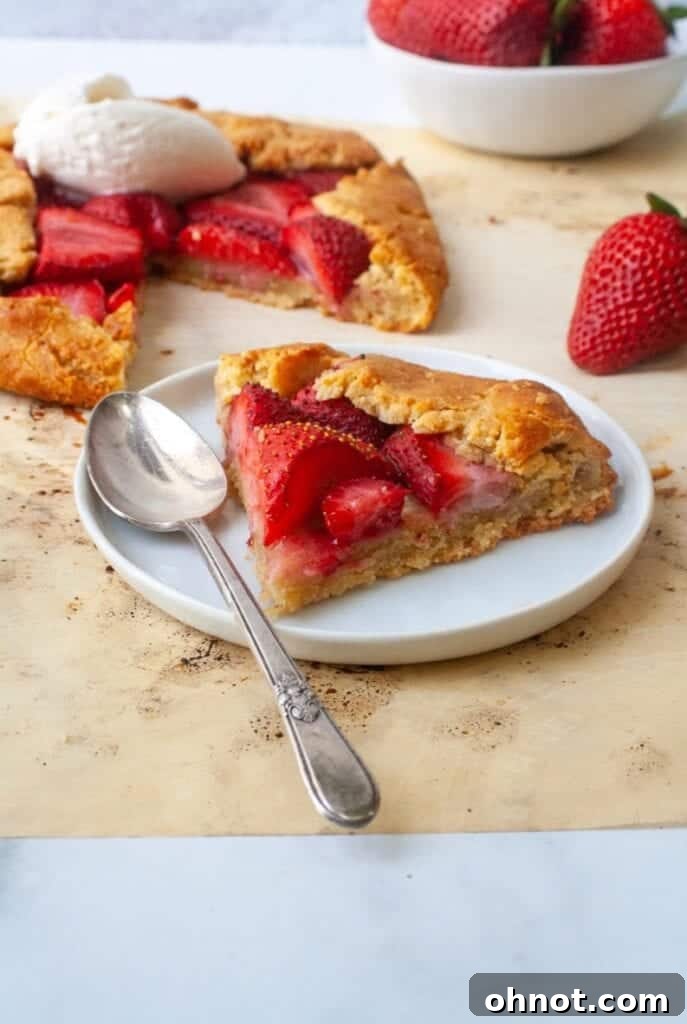 A beautifully baked gluten-free strawberry galette, sliced and presented on a white plate, ready for dessert.