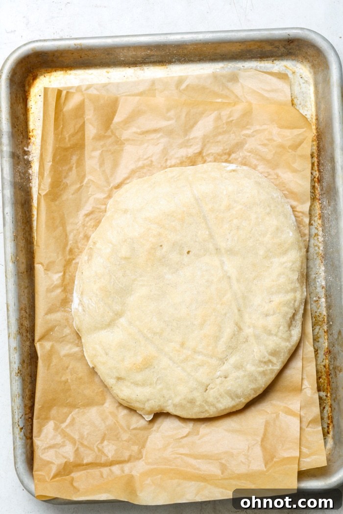 A perfectly pre-baked pizza crust, golden brown and slightly puffed, ready for toppings.