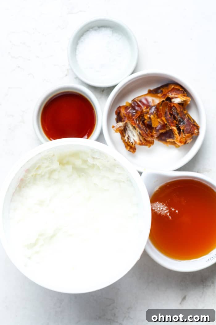 Essential ingredients laid out for making cottage cheese ice cream, including cottage cheese, honey, vanilla, salt, and dates.
