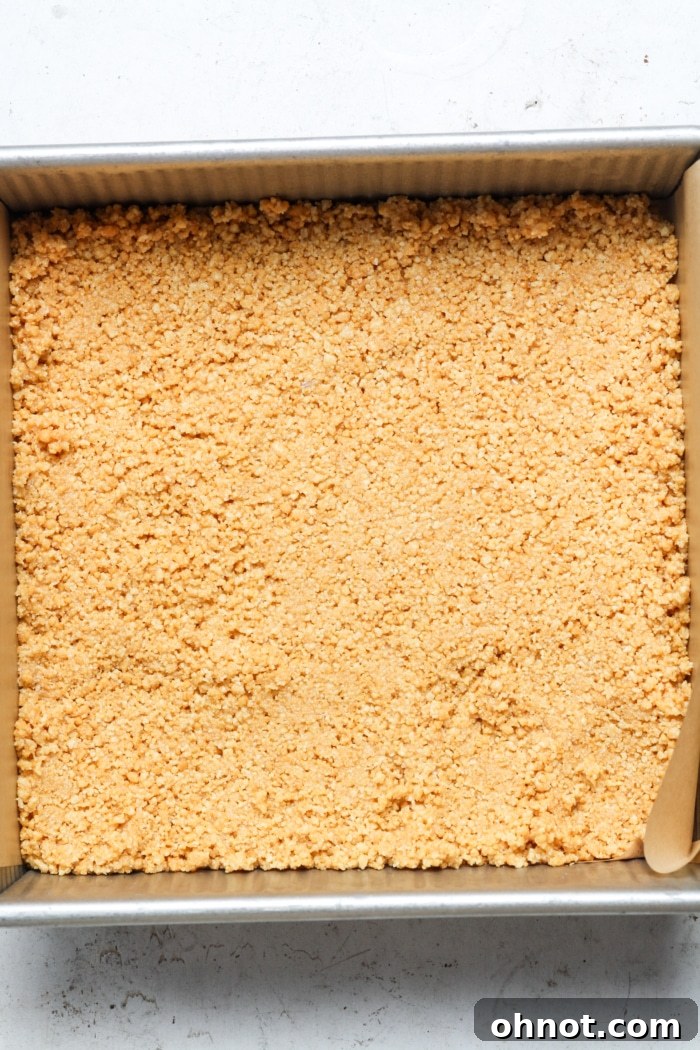 Shortbread crust pressed into a square baking pan.