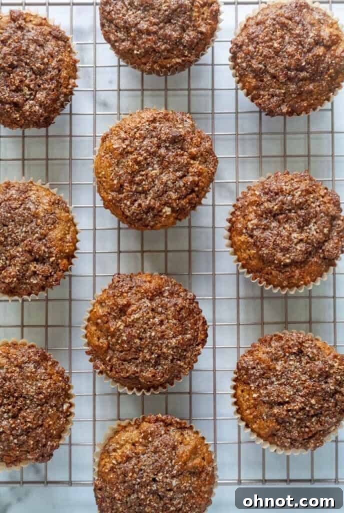 Freshly baked apple muffins with crumb topping cooling on a wire rack