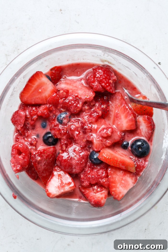 A bowl of vibrant fresh strawberries mixed with other filling ingredients.