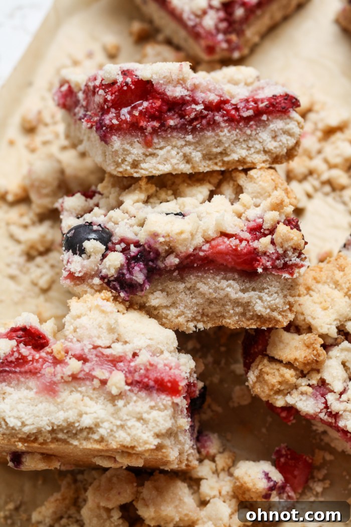 A stack of perfectly cut strawberry crumble bars, ready to be enjoyed.