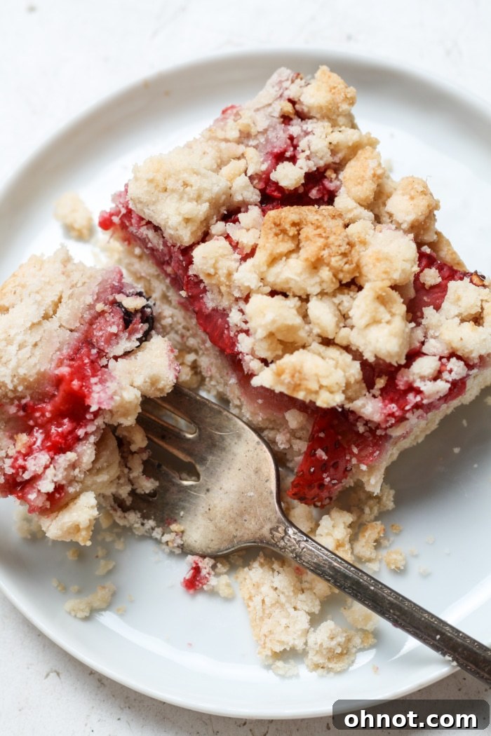 A close-up of a strawberry crumb dessert, showcasing the textures and fresh fruit.