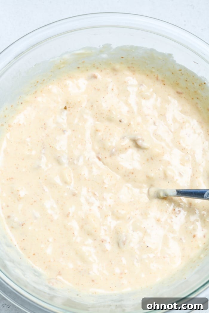 Close-up of creamy yellow batter with oats and oat flour, forming a smooth consistency.