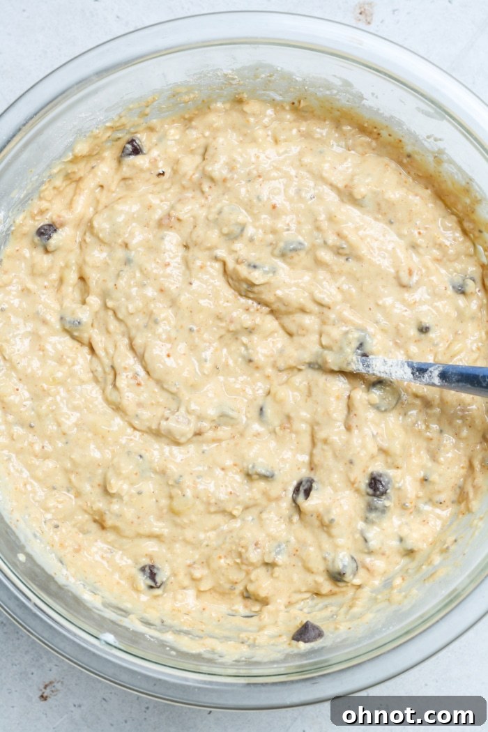 Thick banana bread batter studded with dark chocolate chips, ready for baking.