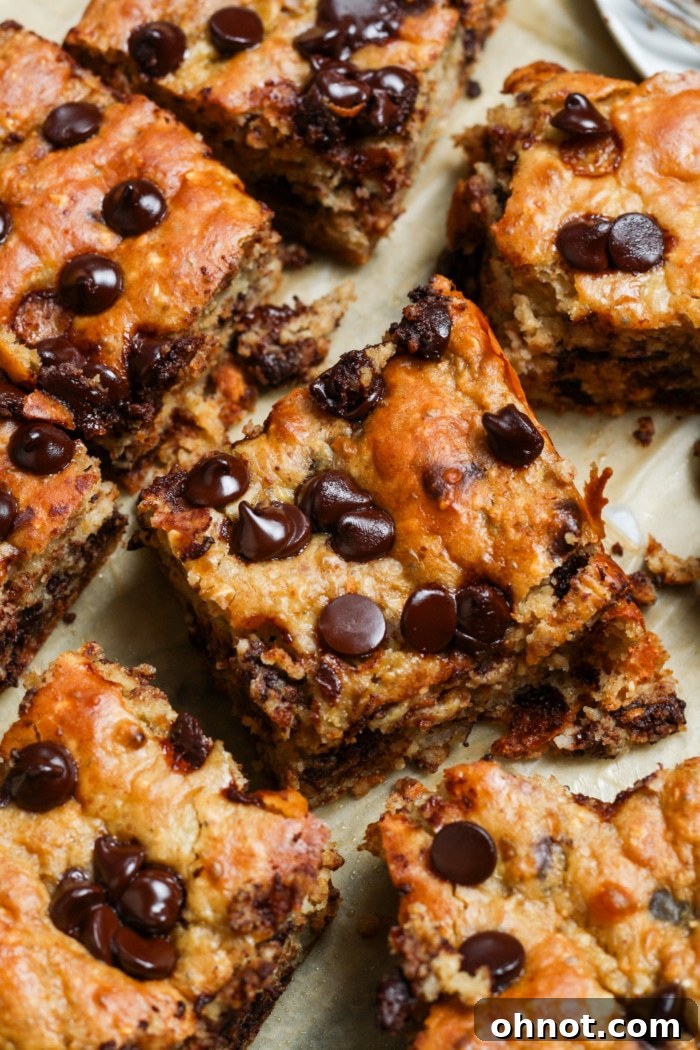 Close-up of a stack of gooey banana chocolate chip bar slices, showing the moist interior and melted chocolate.
