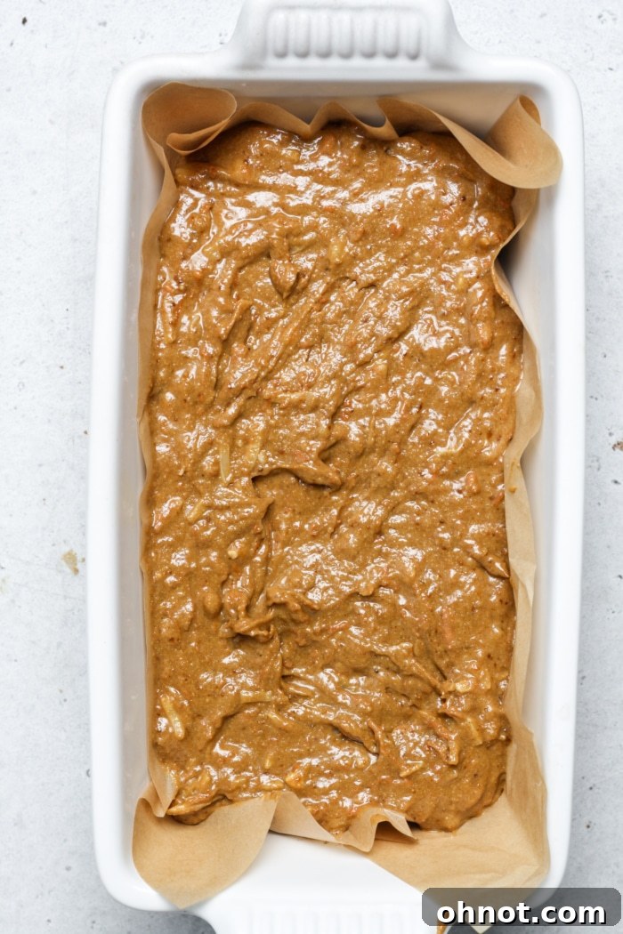 Loaf pan filled with smooth orange batter, evenly spread and ready to be placed into the oven.