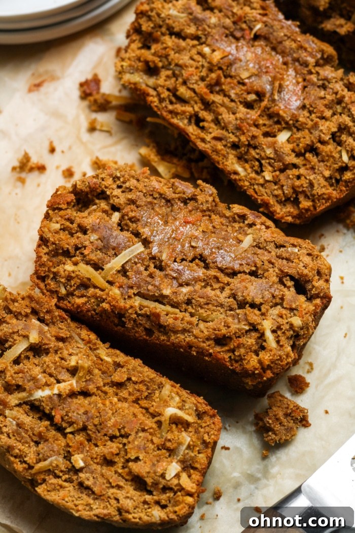 A whole loaf of freshly baked carrot cake banana bread, showing its rustic texture and vibrant carrot specks, resting on a cooling rack.