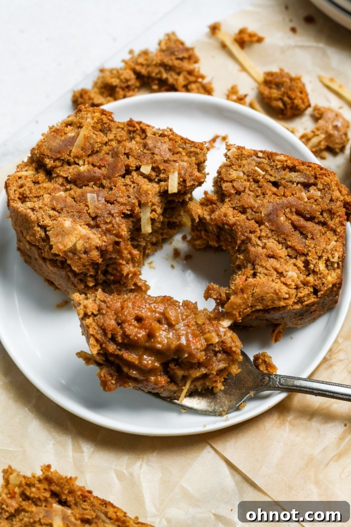A close-up of a slice of carrot cake banana bread, showing its moist crumb, specks of carrot, and a golden crust, perfect for a cozy bite.