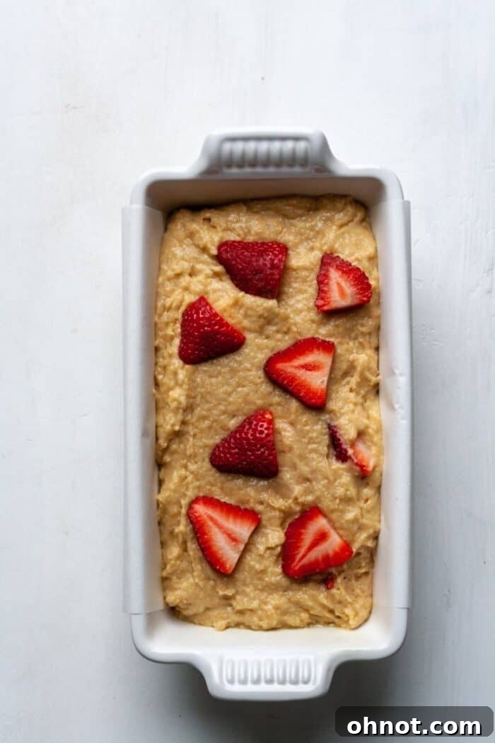 Paleo strawberry banana bread batter in a white bread pan, ready for baking.