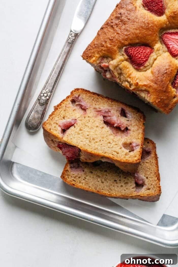 A freshly baked Paleo strawberry banana bread loaf cooling on a metal rack.