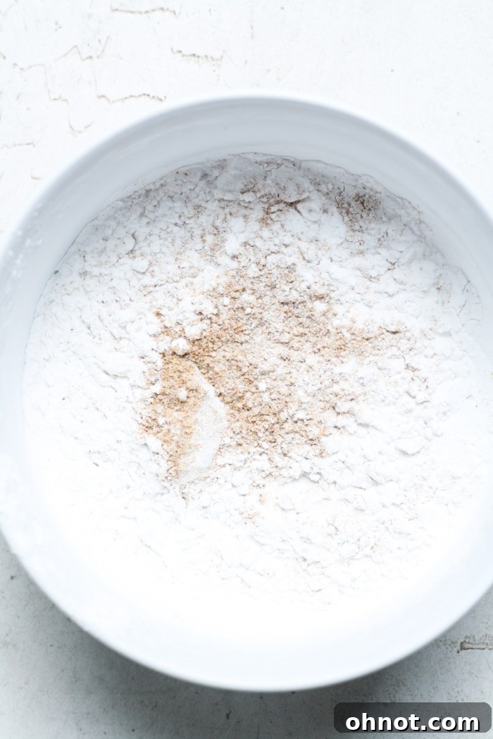 Gluten free flour mixed with spices in a shallow bowl, ready for breading.