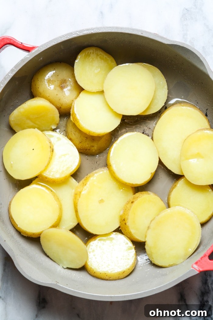 Sliced potatoes cooking in a skillet