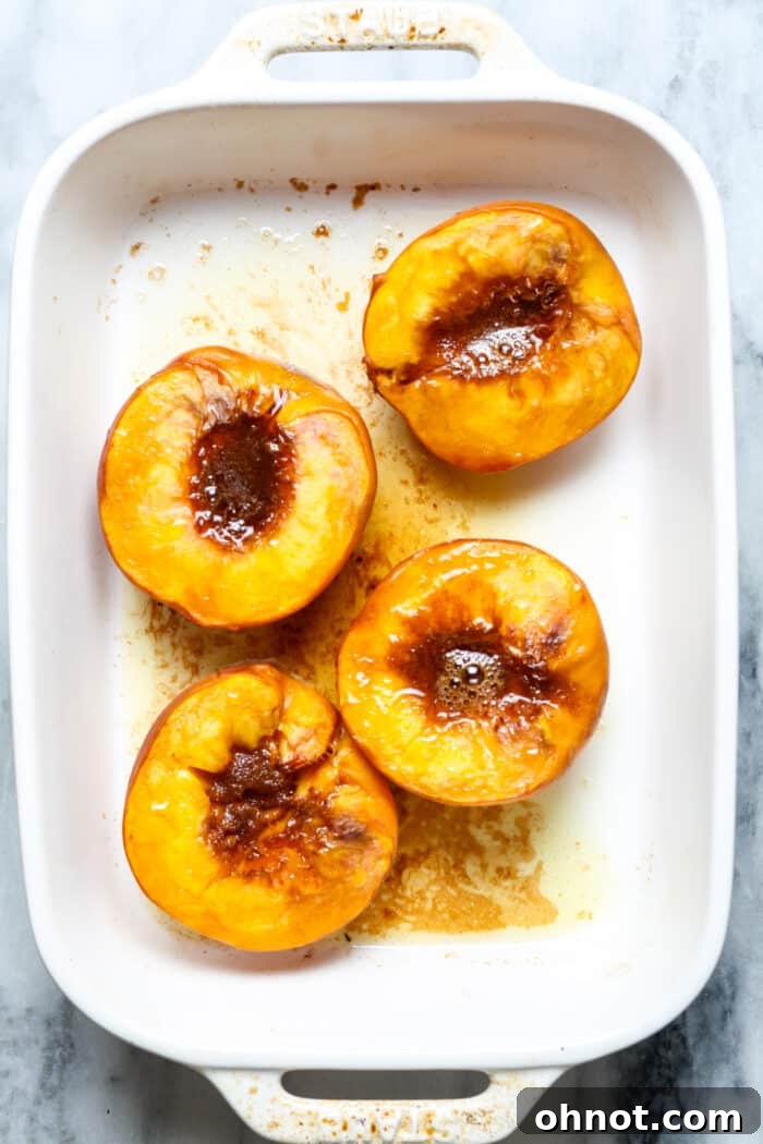 A single baked peach half served in a dish, ready for topping.