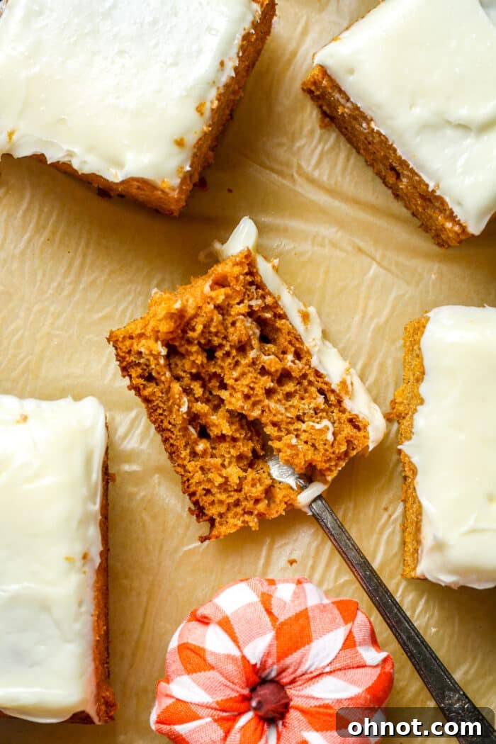 A fork taking a bite from a slice of moist gluten-free pumpkin cake.