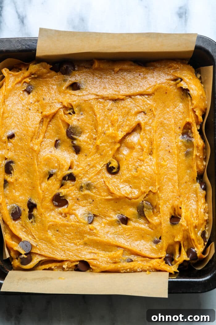 Square pan with pumpkin batter. Ready-to-bake gluten-free pumpkin bars.