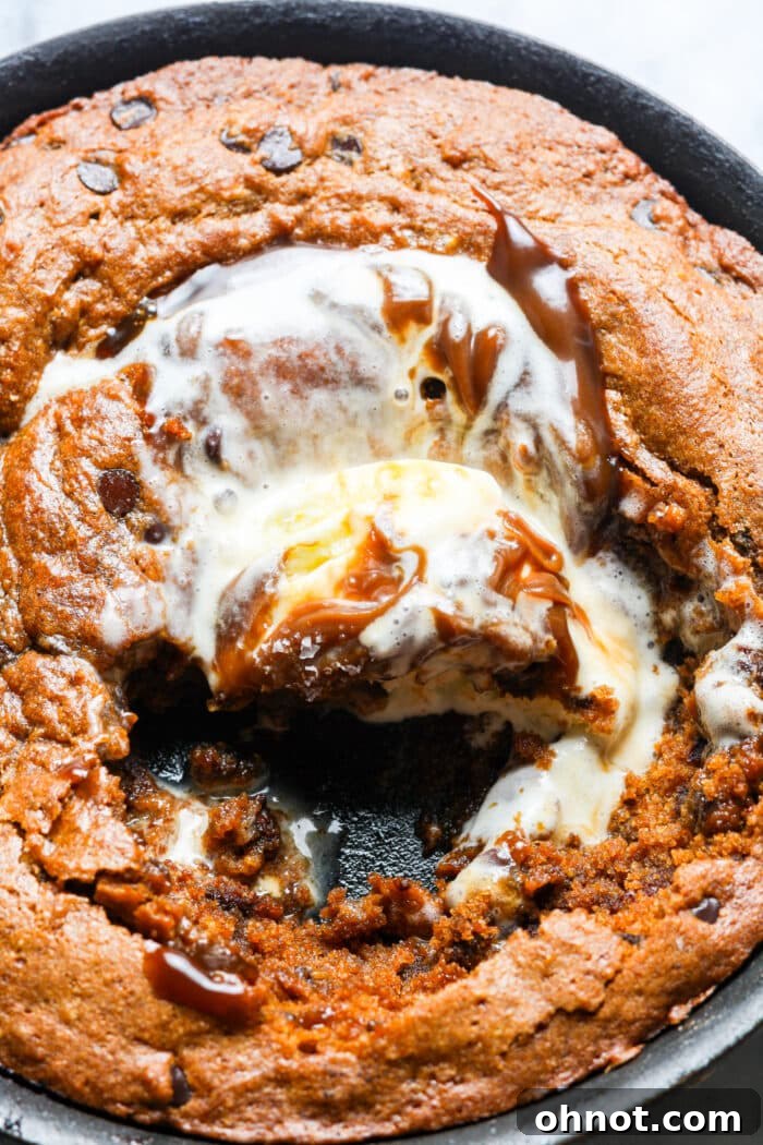 Pumpkin skillet cookie topped with vanilla ice cream and caramel sauce.