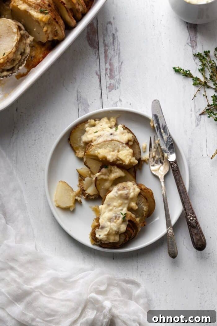 Creamy Whole30 Scalloped Potatoes, beautifully baked in a casserole dish and garnished with fresh herbs.
