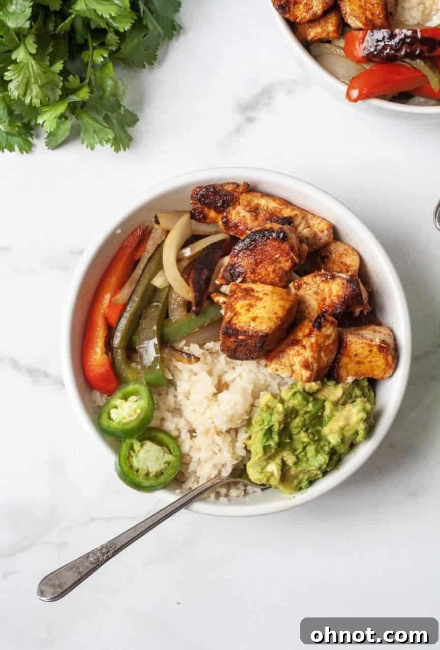 Close-up of a fully assembled Whole30 chicken fajita bowl, showcasing the vibrant ingredients and toppings.