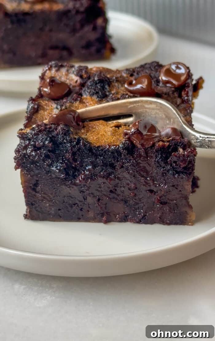Fork digging into a warm piece of chocolate bread pudding.