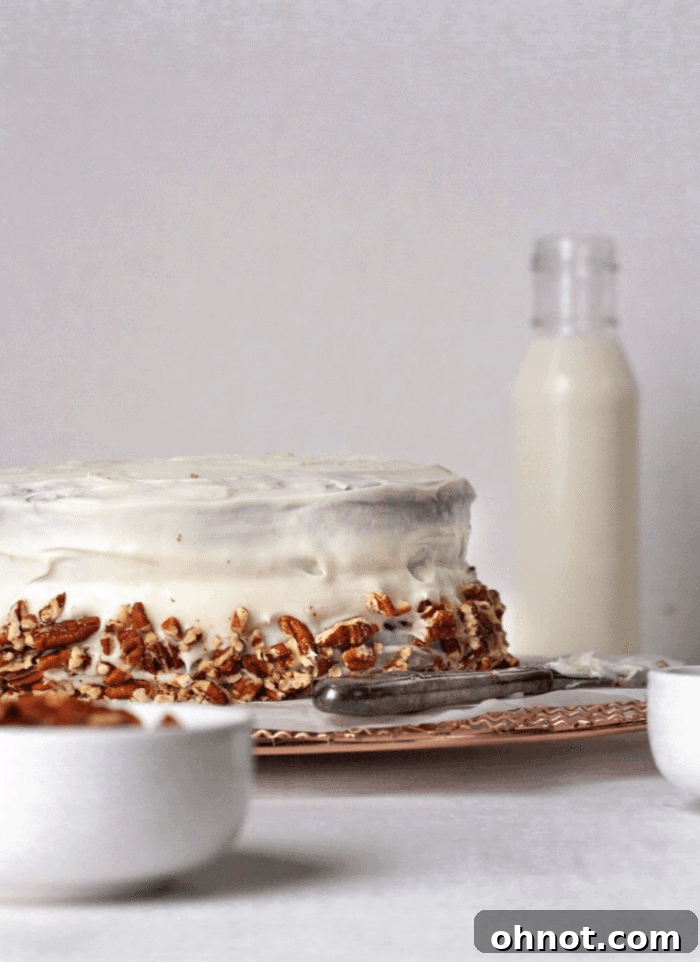 A Paleo Hummingbird cake on a white backdrop with a glass of milk.
