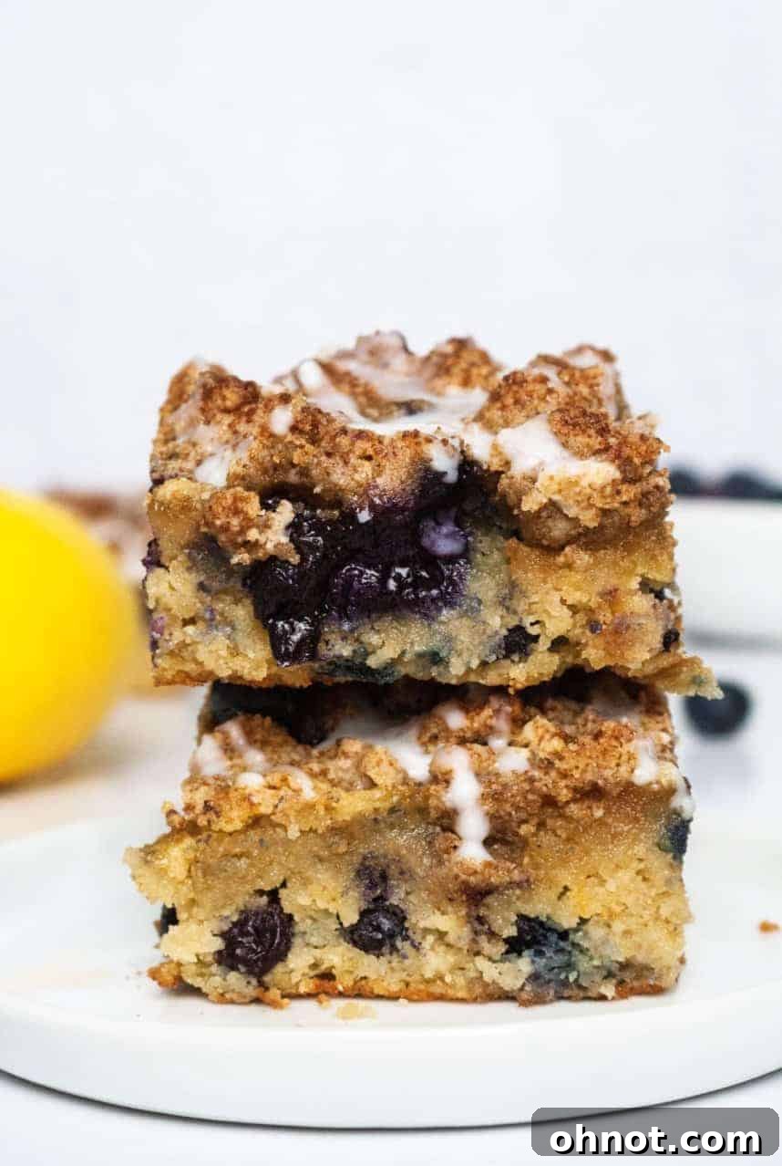 Close-up of a slice of Paleo Lemon Blueberry Coffee Cake, showing the crumb topping, blueberries, and lemon glaze