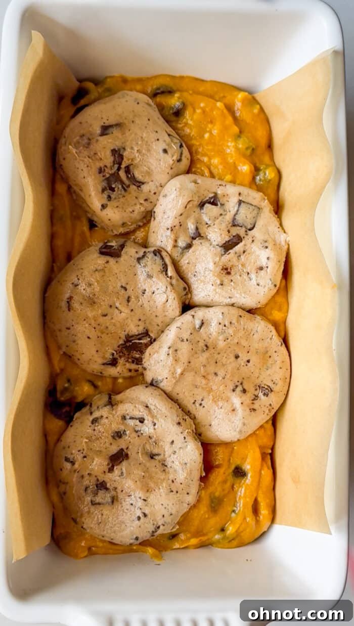Cross-section of cookie dough stuffed pumpkin loaf, showing layers.