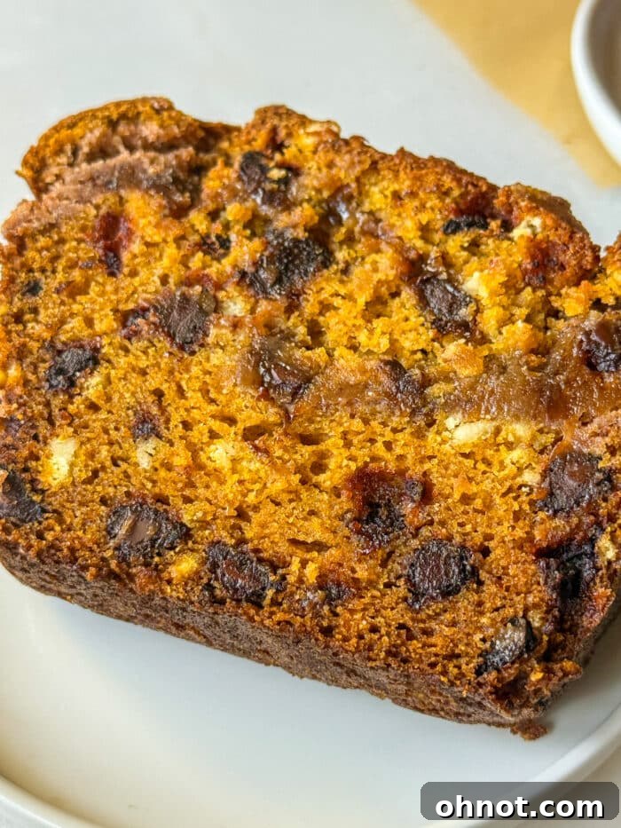 A slice of vibrant orange pumpkin loaf on a plate.