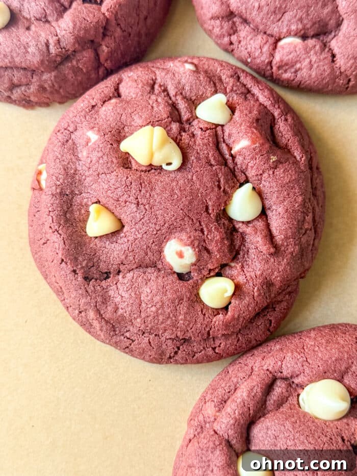 Close-up of freshly baked red velvet cookies with visible white chocolate chips, arranged artfully.