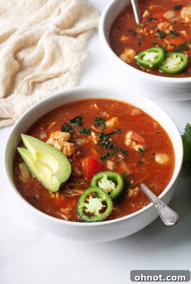 A large pot of simmering Whole30 Chicken Tortilla Soup, ready to be served.
