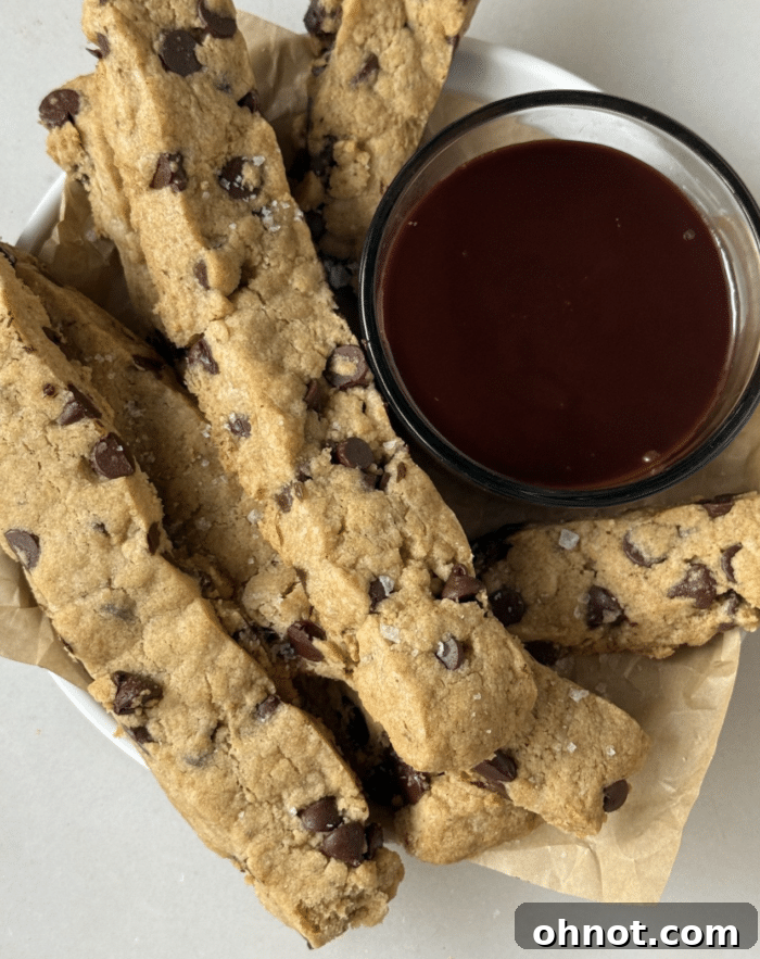 Crispy, golden-brown cookie fries arranged neatly on a parchment-lined baking sheet.