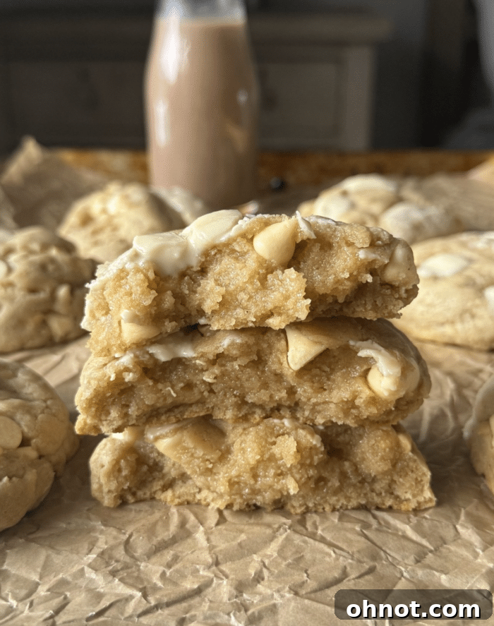 Perfectly baked white chocolate chip cookies on a cooling rack, showcasing their golden edges and soft centers.
