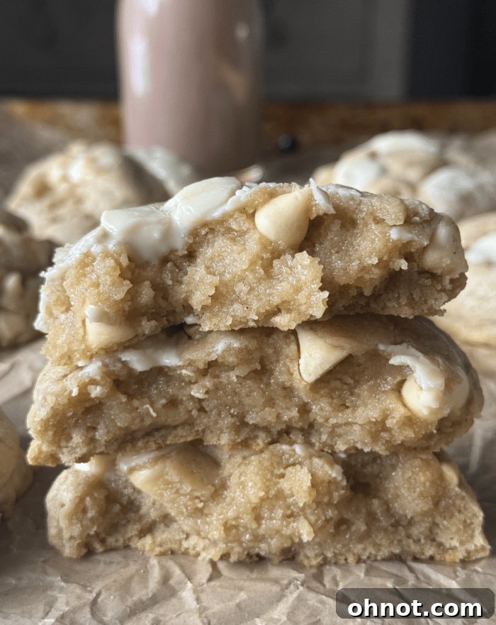 A stack of golden white chocolate chip cookies, indicating their soft texture and deliciousness.