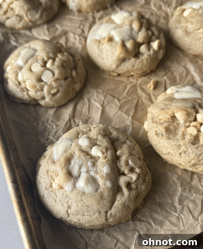 Freshly baked white chocolate chip cookies cooling on a wire rack, ready to be enjoyed.