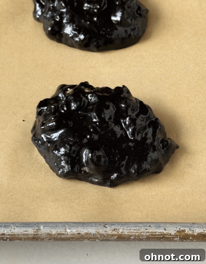 Scoops of gooey chocolate protein cookie dough on parchment paper