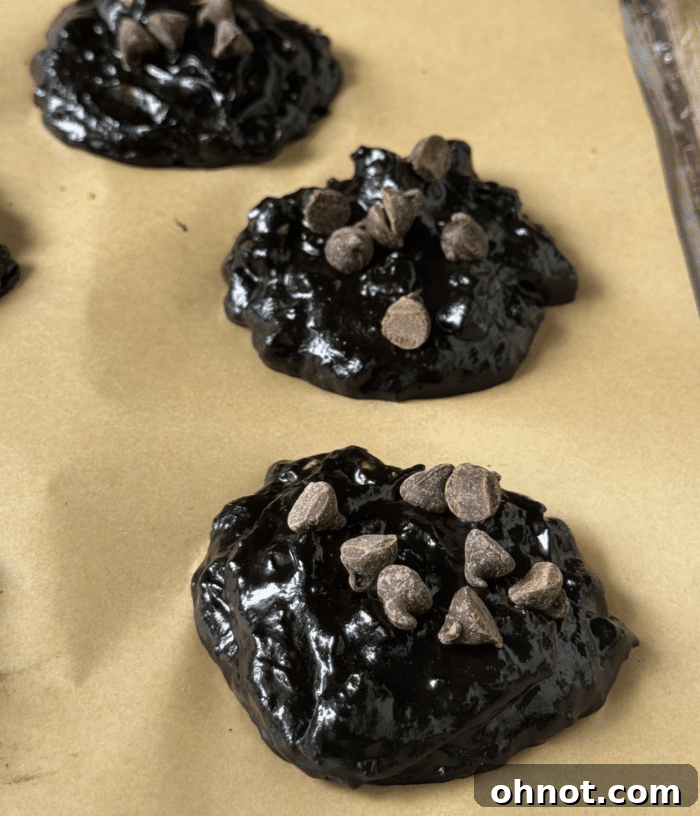 Freshly baked double chocolate protein cookies cooling on a baking sheet