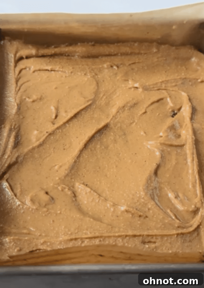 Creamy peanut butter spread evenly in the baking pan.