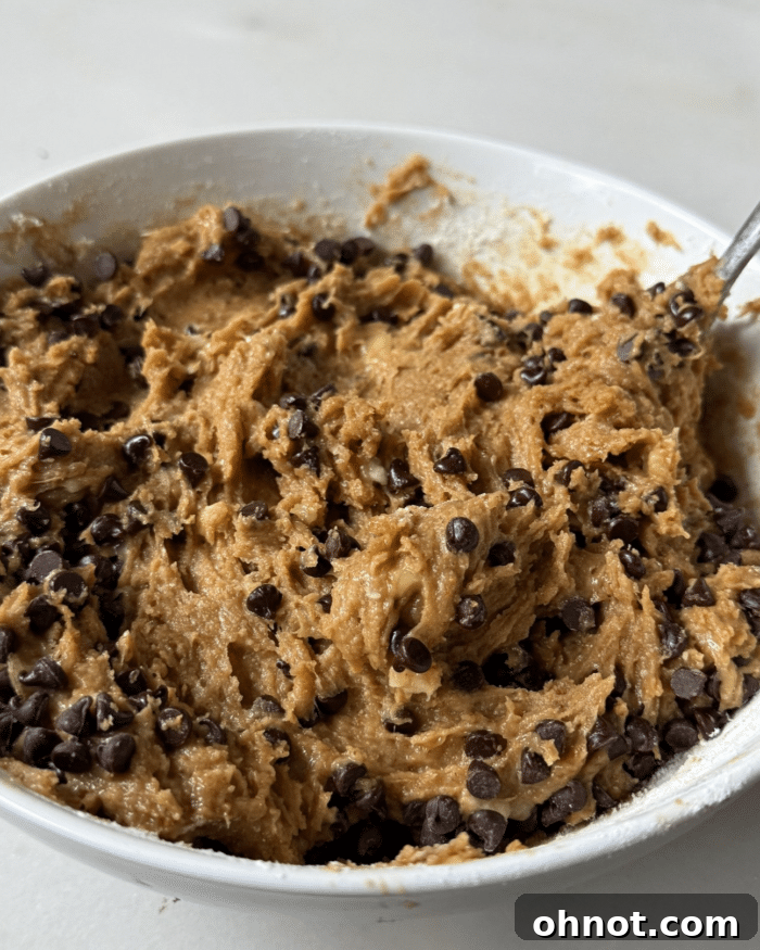 Thick and luscious peanut butter banana bread batter with chocolate chips folded in, ready for assembly.