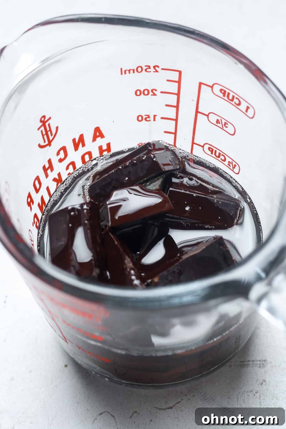 Dark chocolate chips in a glass bowl, ready to be melted.